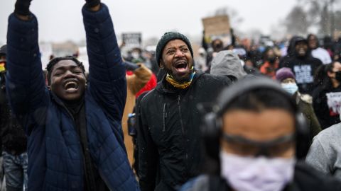 Minnesota State Rep. John Thompson, center, marches with protesters outside the Brooklyn Center police headquarters on Tuesday in Brooklyn Center, Minnesota.