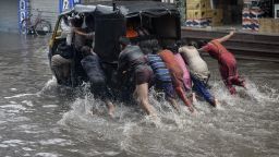 In this file photo taken on June 29, 2017 Indian children help to push an auto rickshaw along a flooded street after heavy rain in Jalandhar, as the monsoon season begins. (Photo by SHAMMI MEHRA / AFP) (Photo by SHAMMI MEHRA/AFP via Getty Images)
