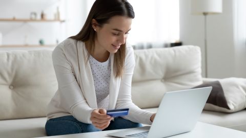 underscored woman on laptop with credit card