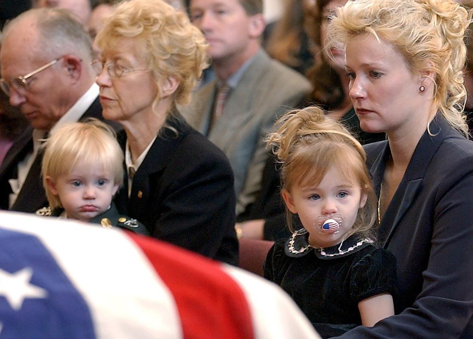 Renae Chapman holds her 2-year-old daughter, Amanda, during the funeral service for her husband, Army Sgt. 1st Class Nathan R. Chapman, in Fort Lewis, Washington, in January 2002. He was the first US soldier to be killed by enemy fire during the war in Afghanistan.