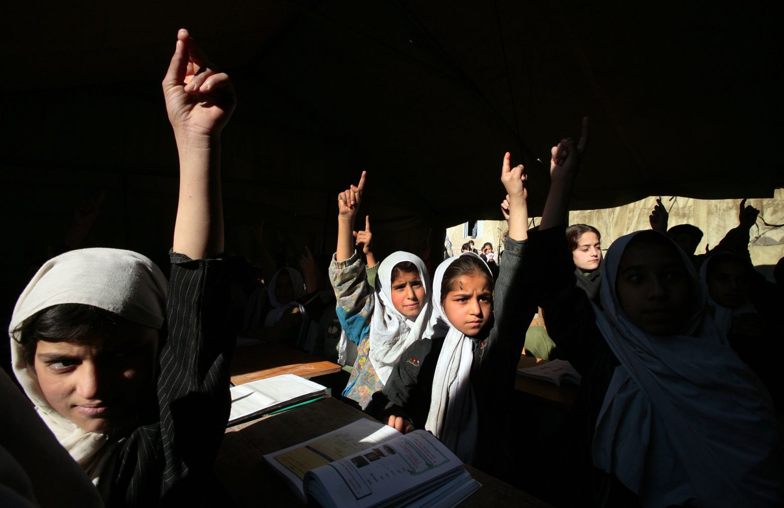 Girls at the Bibi Mahroo High School raise their hands during an English class in Kabul in November 2006. After the fall of the Taliban, millions of Afghan girls <a href="https://www.cnn.com/2012/09/26/world/asia/cnnheroes-afghan-schoolgirls" target="_blank">were able to attend school</a> and get the education that their mothers couldn't.