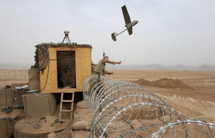 US Marine Sgt. Nicholas Bender launches a Raven surveillance drone near the remote village of Baqwa, Afghanistan, in March 2009.
