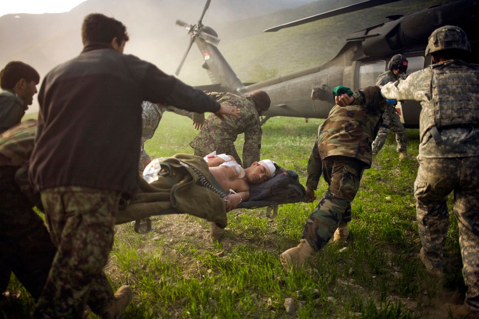 Afghan soldiers rush a wounded police officer to an American helicopter in Afghanistan's Kunar province in March 2010.