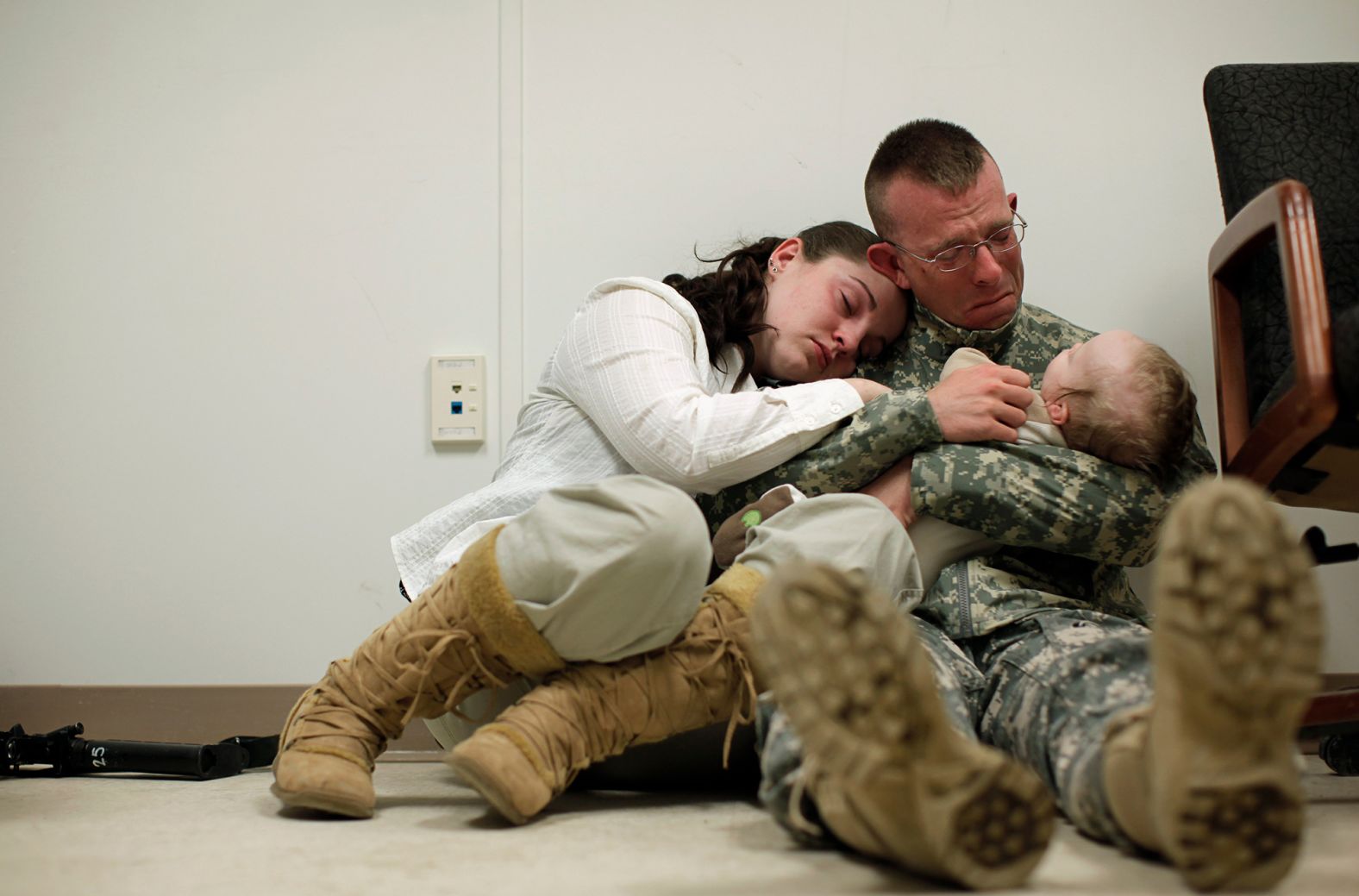 Sgt. Brian Keith sits with his wife, Sara, and their baby son, Stephen, just before his deployment to Afghanistan in March 2010. A few months earlier, President Barack Obama announced a surge of 30,000 additional troops. This new deployment would bring the US total to almost 100,000 troops, in addition to 40,000 NATO troops.