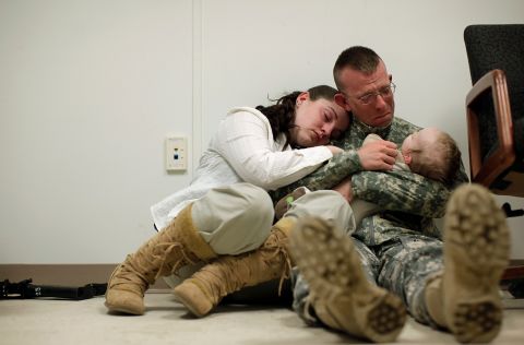 Sgt. Brian Keith sits with his wife, Sara, and their baby son, Stephen, just before his deployment to Afghanistan in March 2010. A few months earlier, President Barack Obama announced a surge of 30,000 additional troops. This new deployment would bring the US total to almost 100,000 troops, in addition to 40,000 NATO troops. 