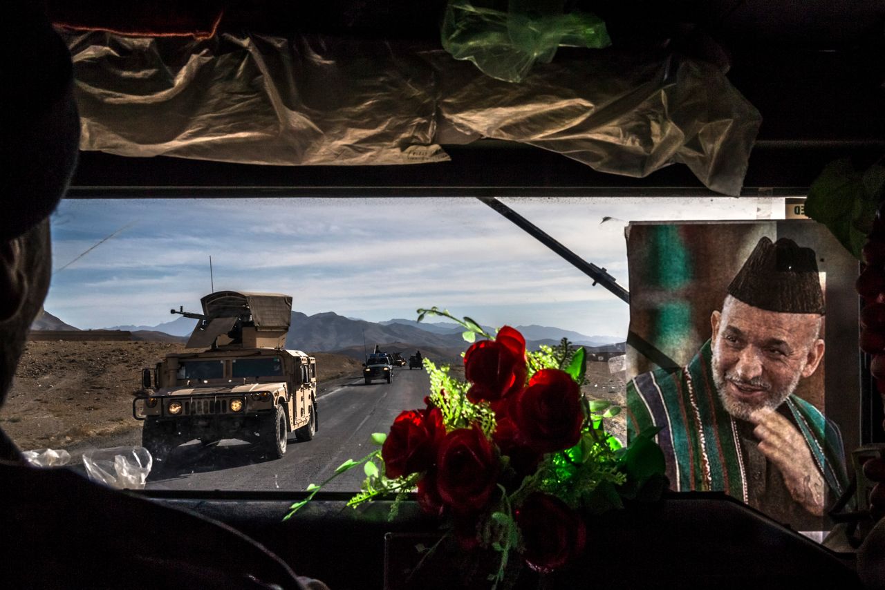 An Afghan army convoy travels Highway 1 in Afghanistan's Wardak province in November 2013. The picture at right shows Afghan President Hamid Karzai.