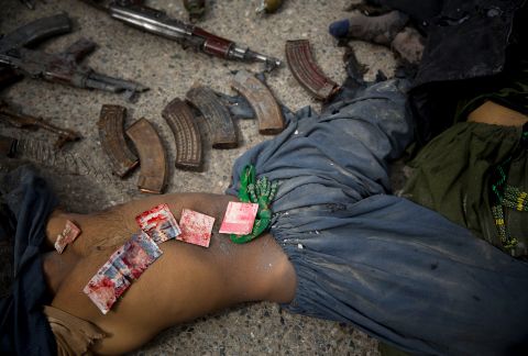 Blood-stained Pakistani bank notes are displayed on the body of a dead suicide bomber after an attack in Kandahar, Afghanistan, in March 2014. Police said they found the bank notes in his pocket. Three insurgents tried to storm the former headquarters of Afghanistan's intelligence service in southern Kandahar. They died in a gunbattle with security forces, officials said.