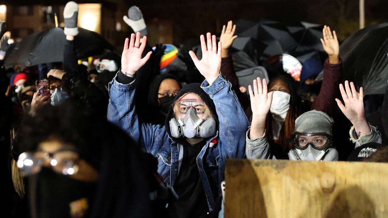 Demonstrators hold their hands up as they protest outside of the Brooklyn Center Police Department on Wednesday.