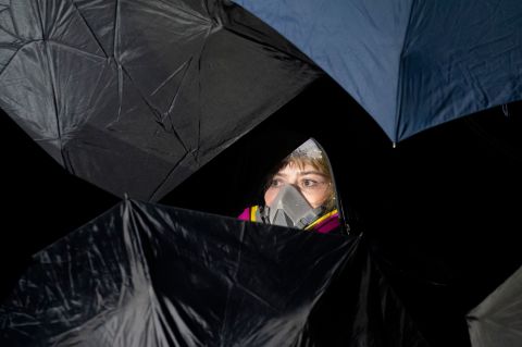 A demonstrator is seen behind umbrellas.