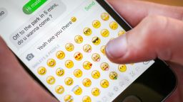 A boy uses emojis while texting