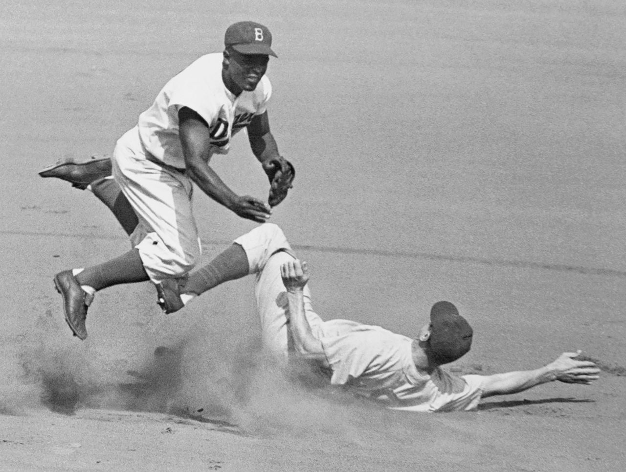 Robinson leaps into the air to try to turn a double play in 1952.