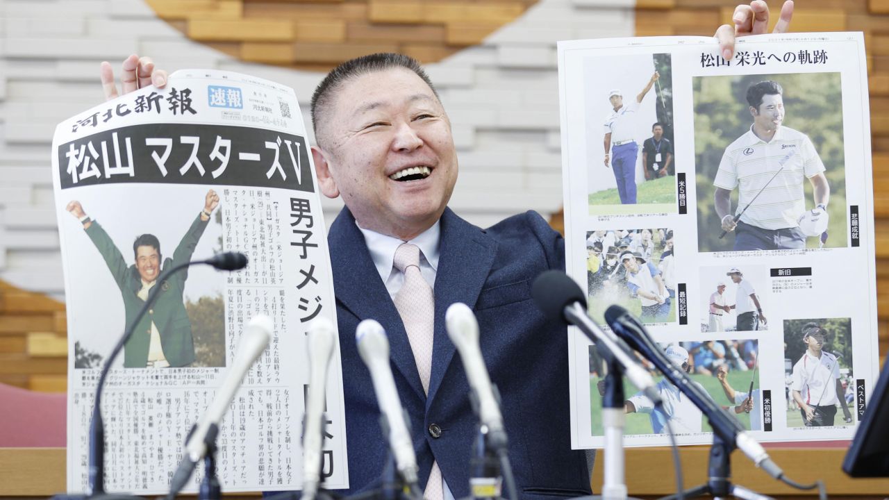 Yasuhiko Abe, who coached golfer Hideki Matsuyama during his Tohoku Fukushi University years, holds special editions of newspapers featuring Matsuyama's Masters victory. 