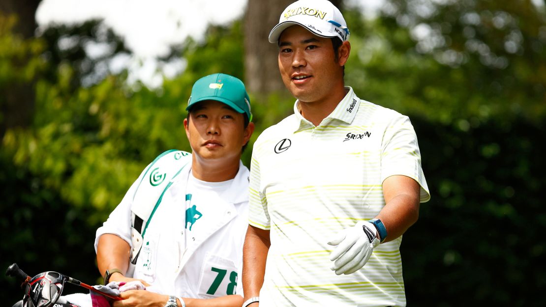 Matsuyama talks with his caddie Shota Hayafuji on the second tee during the final round of the Masters.