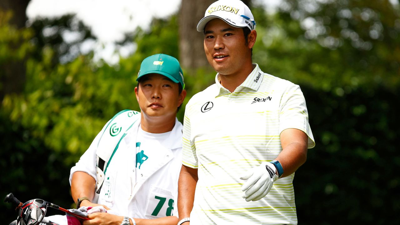 Matsuyama talks with his caddie Shota Hayafuji on the second tee during the final round of the Masters.