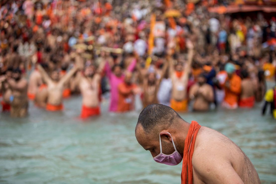 A Sadhu wearing a face mask takes a holy dip in the Ganges River during the Kumbh Mela festival in Haridwar, India, on April 12.