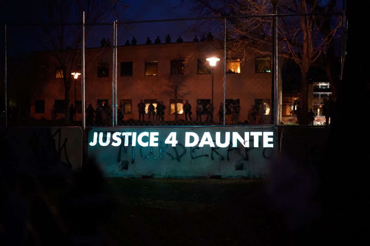 A message is projected onto the barrier separating demonstrators from police.