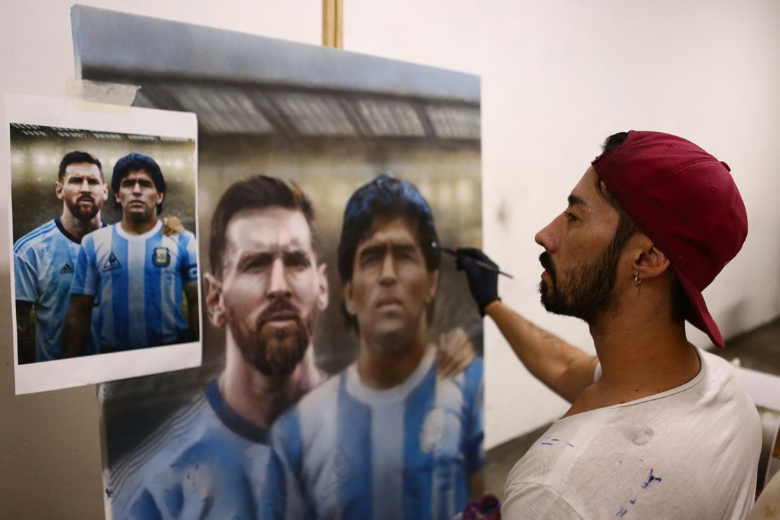 Artist Maximiliano Bagnasco shows off his painting of Diego Maradona.