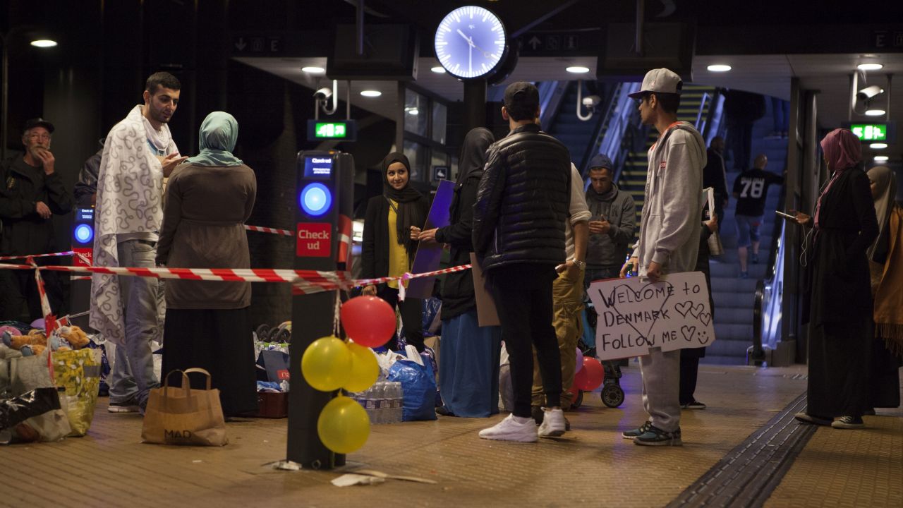 A small group of people in Copenhagen Central Station wait to welcome Syrian refugees on September in 2015. 