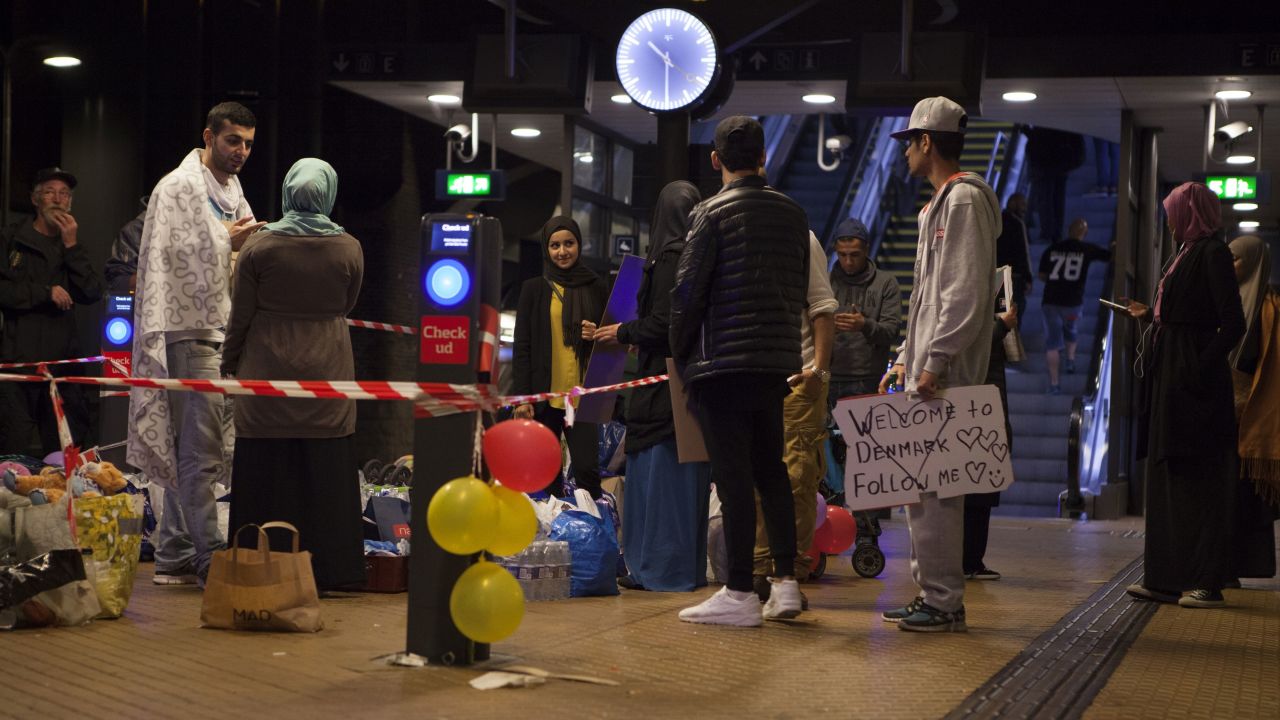A small group of people in Copenhagen Central Station wait to welcome Syrian refugees on September in 2015.