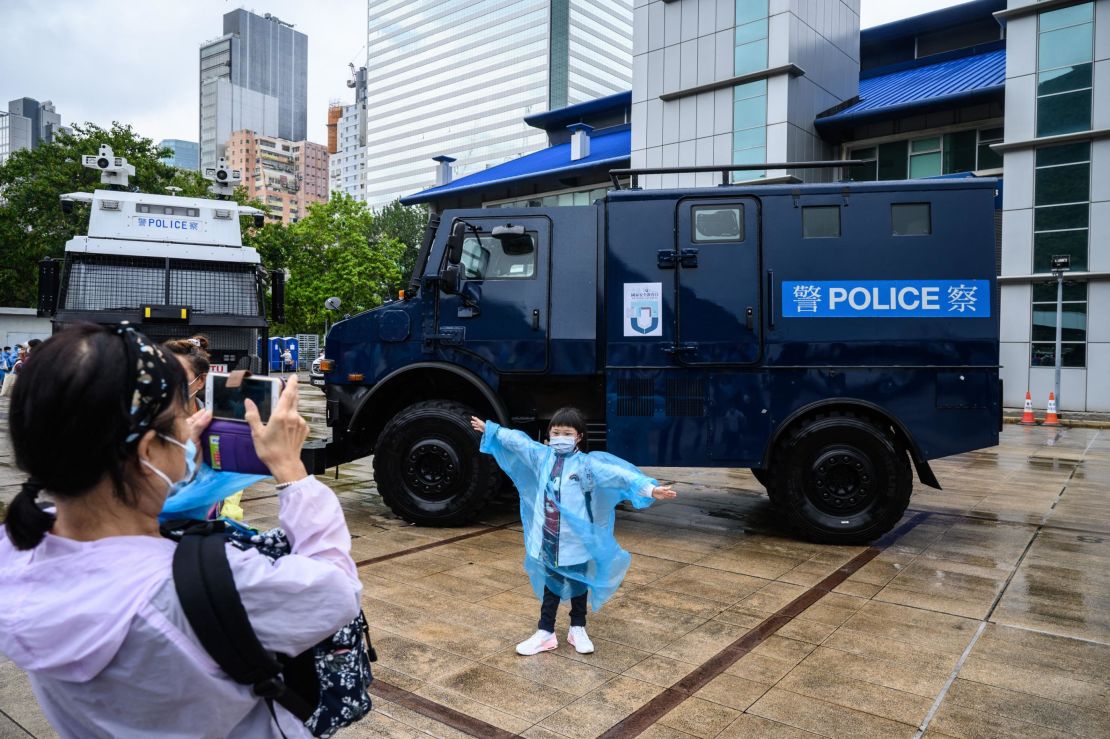 A young visitor poses in front of a police vehicle at the city's police college during an open day to celebrate the National Security Education Day in Hong Kong on April 15, 2021.
