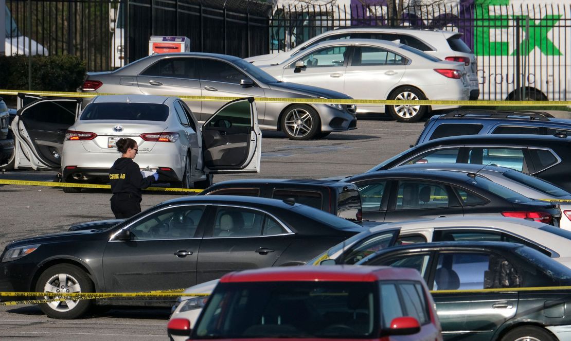 A crime lab technician works Friday in the parking lot of the site of the mass shooting at a FedEx facility in Indianapolis.