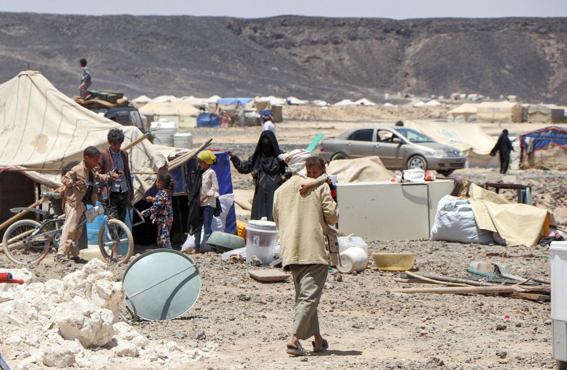 A man carries a child at a camp for displaced people on Marib's outskirts on March 28. Residents were preparing to flee due to the camp's proximity to the fighting. 