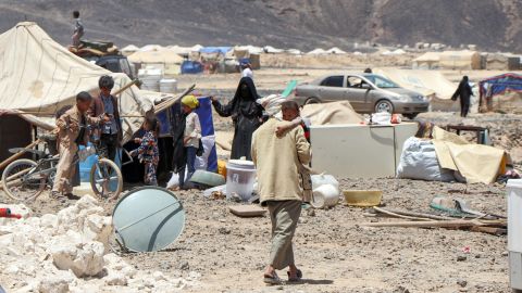 A man carries a child at a camp for displaced people on Marib's outskirts on March 28. Residents were preparing to flee due to the camp's proximity to the fighting.