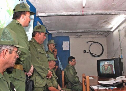 Cuban Army officers watch a message from Castro as he gives the order to begin military exercises conducted by hundreds of thousands of Cuban troops and civilians in Cuba in 2004.