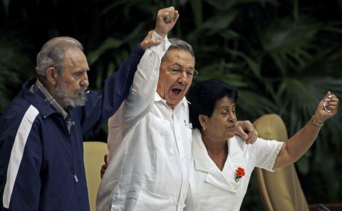 Fidel Castro raises his brother's hand as they sing the International Socialist Anthem during the 6th Communist Party Congress in Havana in 2011.