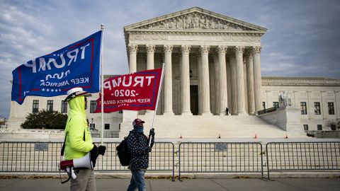 People hold campaign flags supporting President Donald Trump outside of the US Supreme Court on Wednesday, Dec. 9, 2020. 