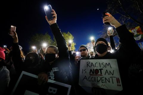 People hold their phones up while protesting outside the Brooklyn Center Police Department on Friday, April 16.