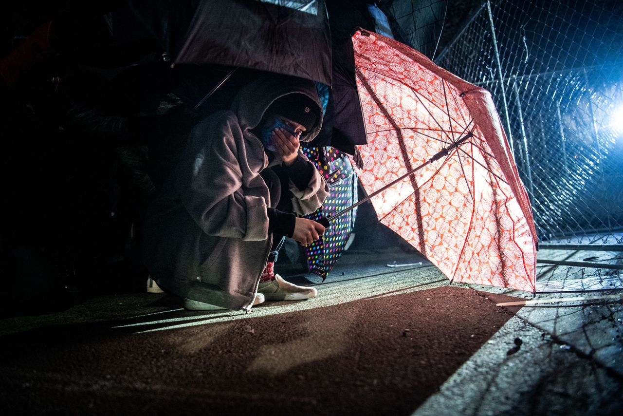 Demonstrators protect themselves with umbrellas against tear gas and pepper balls.