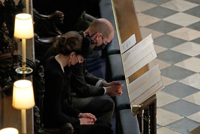 Prince William and his wife, Catherine, the Duchess of Cambridge, bow their heads in prayer during the ceremony.