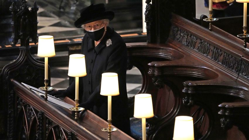 Britain's Queen Elizabeth II takes her seat alone in St. George's Chapel during the funeral of Prince Philip, the man who had been by her side for 73 years, at Windsor Castle, Windsor, England, Saturday April 17, 2021. Prince Philip died April 9 at the age of 99 after 73 years of marriage to Britain's Queen Elizabeth II. (Yui Mok/Pool via AP)