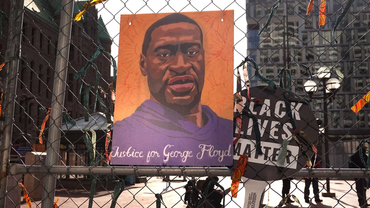 A picture of George Floyd hangs on a fence barrier that surrounds the Hennepin County Government Center on March 30, 2021 in Minneapolis, Minnesota.