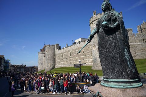 A crowd gathers near the Queen Victoria statue for a two-minute silence outside Windsor Castle during the funeral of Prince Philip.