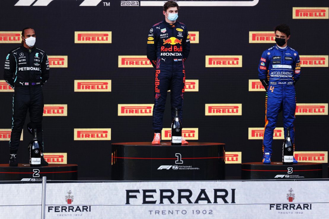 Lewis Hamilton, Max Verstappen and Lando Norris stand on the podium.