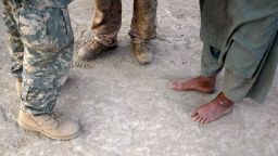 A U.S. Marine (C) talks through his interpreter (L) to an Afghan man during a patrol on July 6, 2009 in Mian Poshteh, Afghanistan. 