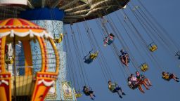 WILDWOOD, NJ - JULY 03:  People wearing face masks ride an attraction at an amusement pier on July 3, 2020 in Wildwood, New Jersey.  New Jersey beaches have reopened for the July 4th holiday as some coronavirus restrictions have been lifted, along with casinos, amusement rides and water parks at limited capacity. (Photo by Mark Makela/Getty Images)