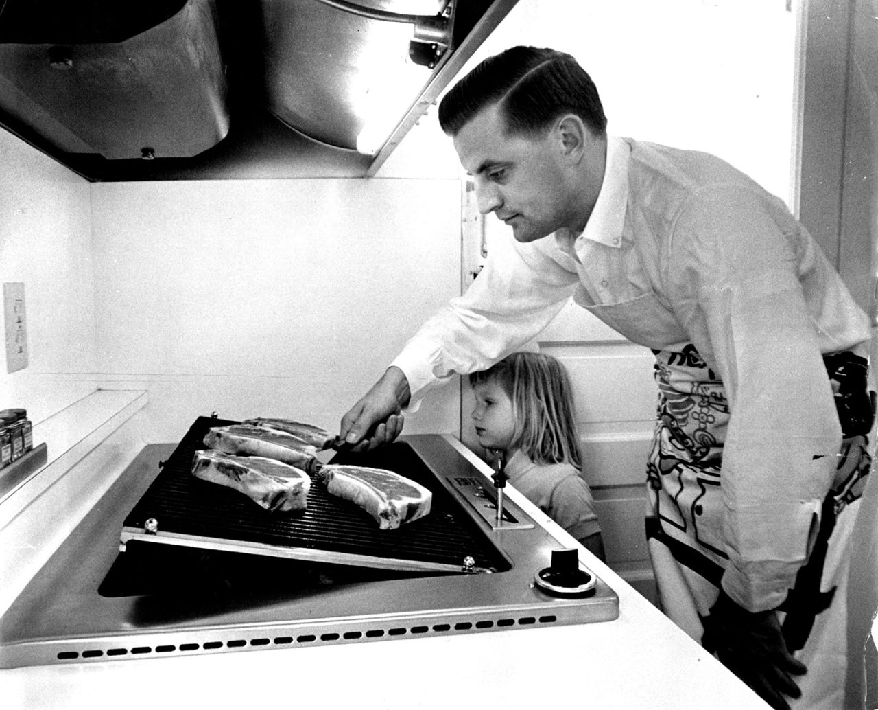 Mondale and his 4-year-old daughter Eleanor cook steaks in his family's new kitchen in Minneapolis on June 20, 1964.