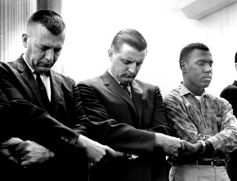 Mondale, center, clasps his hands and bows his head in a prayer line for civil rights demonstrators in Selma, Alabama, in Unity Unitarian Church in St. Paul, Minnesota, on March 11, 1965.