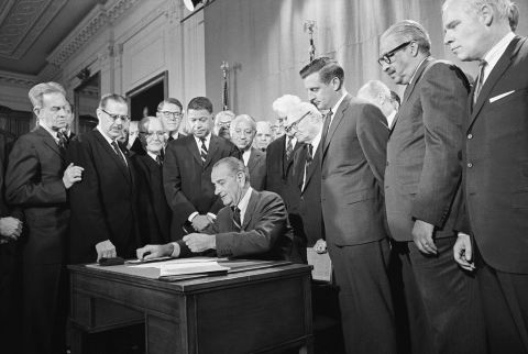 Mondale and other senators watch as Johnson signs the Civil Rights Act of 1968 into law on April 11, 1968.