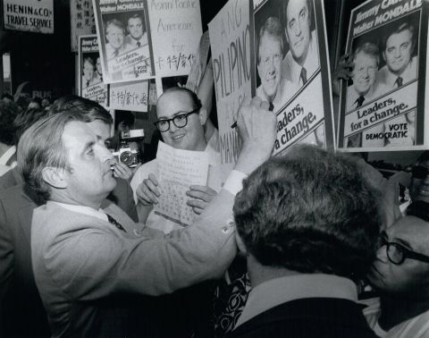 Mondale signs a poster of him and Carter while campaigning in New York on October 4, 1976.