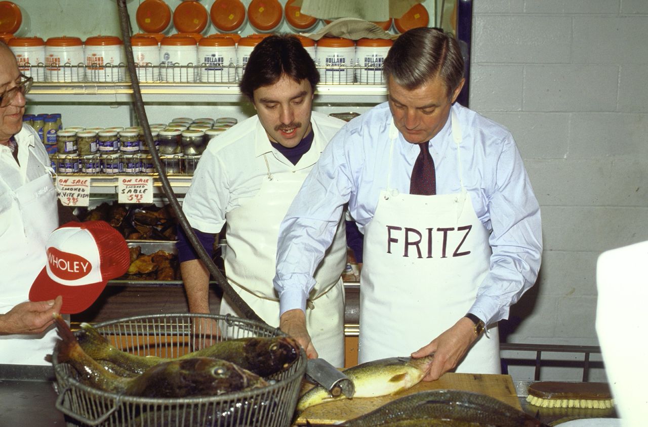 Mondale scales a fish during a campaign stop in Pittsburgh in April 1984. His nickname, "Fritz," is printed on his apron.