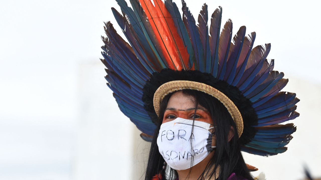 An indigenous woman takes part in a protest along with people from various ethnic groups in a protest against the proposal of the federal government to legalize mining in indigenous lands, in front of Planalto Palace in Brasilia on April 19, 2021.