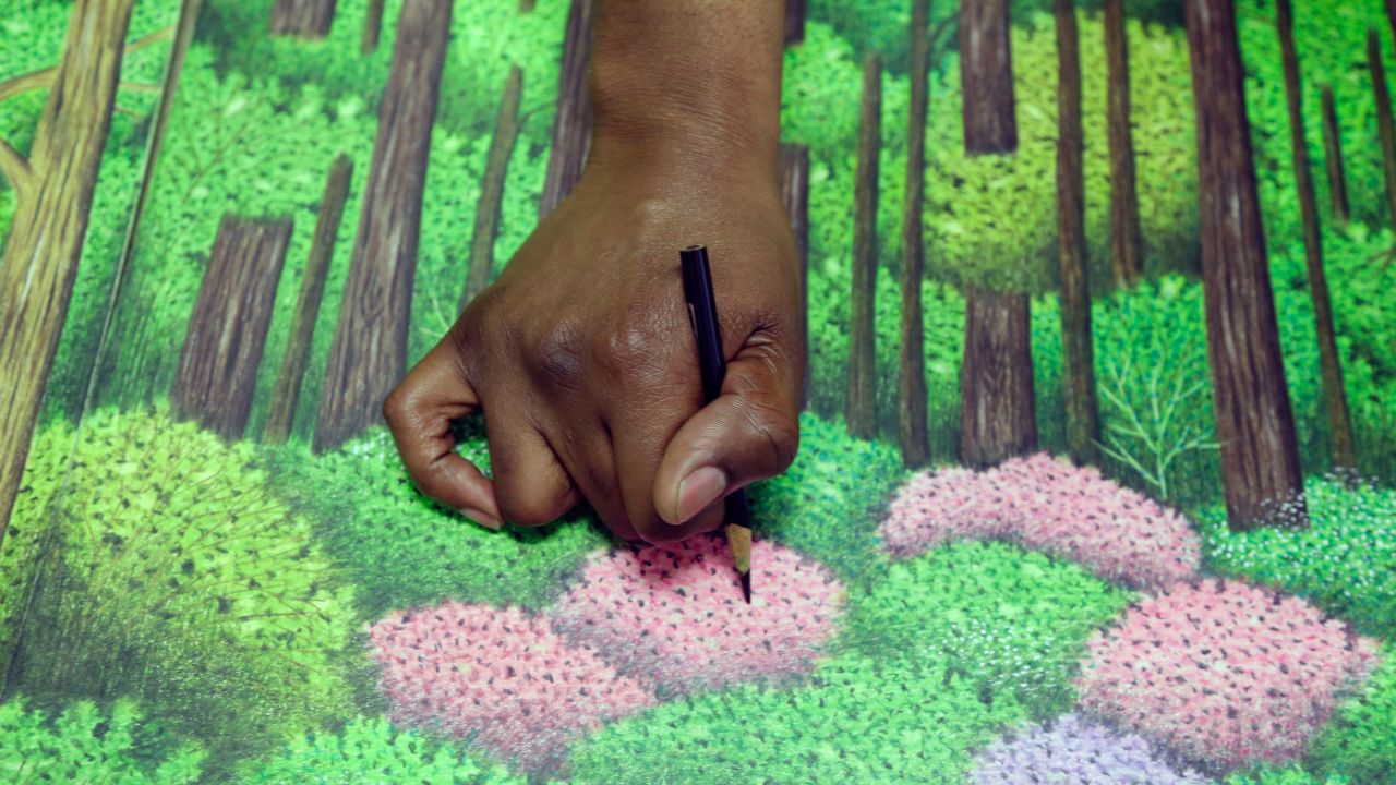 Dixon touches up a golf drawing he is creating in prison.