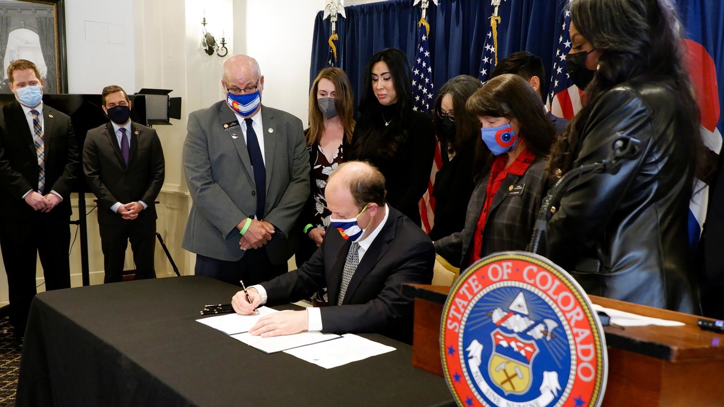 Colorado Gov. Jared Polis, signs into law a bill from the state Senate to tighten gun regulations on Monday, April 19, 2021, in Denver.