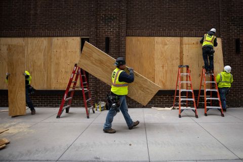 Workers board up businesses near the Hennepin County Government Center on April 20.