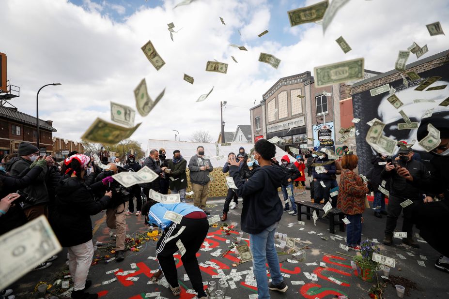 Money is tossed in the air as people celebrate the verdict at George Floyd Square in Minneapolis.