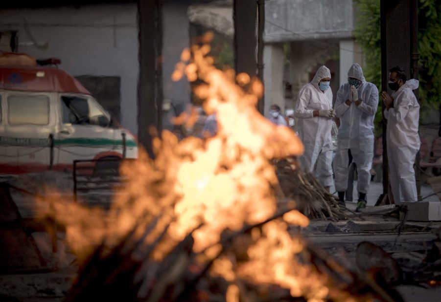 Relatives of a patient who died from Covid-19 perform his last rites amid other burning pyres at a crematorium in New Delhi.